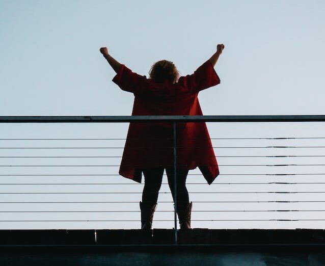 Back View Photo of Standing Woman with Her Hands Raised