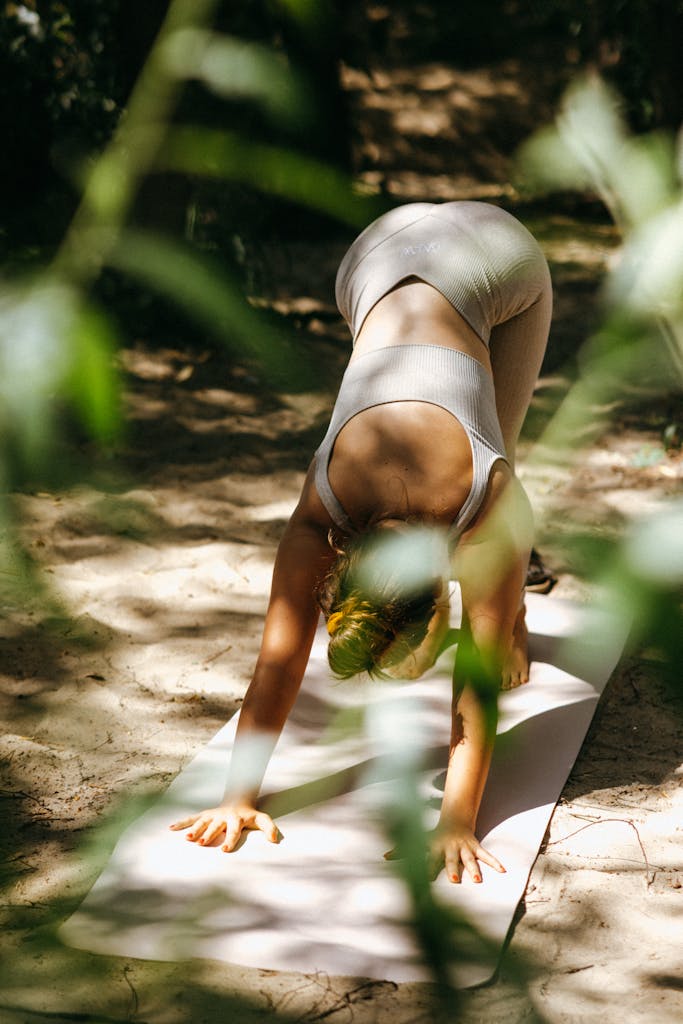 A Woman Doing Yoga on The Sand