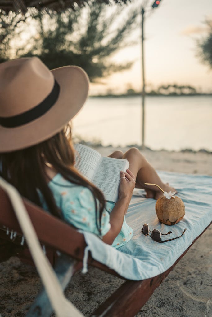 A Woman Lying on a Sun Lounger while Reading a Book