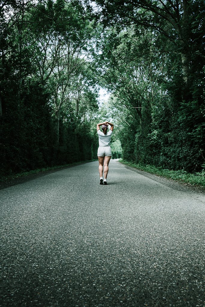 Woman in White T-shirt Walking on trail enjoying outdoors activities.